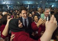 Enkele zojuist aangekomen vluchtelingen maken een selfie met de Canadese Premier Justin Trudeau er ook op. Trudeau wachtte het toestel op het vliegveld van Toronto op toen dit donderdagavond laat (Canadese tijd) landde.