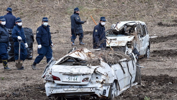 Полицейские во время поисков останков пропавших без вести в районе АЭС Фукусима, Япония. 11 марта 2014. Архивное фото