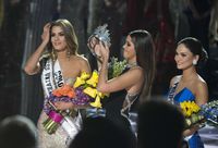 Paulina Vega (M) haalt de kroon van het hoofd van de Colombiaanse Miss Ariadna Gutierrez (L) nadat er een fout is gemaakt in de uitslag bij de Miss Universe verkiezing.