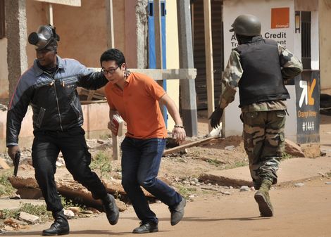 Ontkomen! Een Japanse gast van het Radisson Blu Hotel in Bamako wordt door Malinese troepen in veiligheid gebracht. ren.