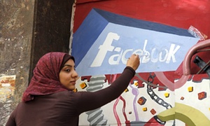 A student from the University of Helwan paints the Facebook logo on a mural in  Cairo, Egypt in 2011.