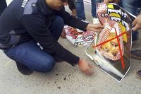 Een demonstrant probeert het portret van de Saudische kroonprins Mohammed bin Nayef in de brand te steken. Na de executie van de sjiitische geestelijke Nimr al-Nimr in Saudi-Arabië is in Irak op diverse plaatsen fel geprotesteerd. Irak is overwegend sjiitisch.