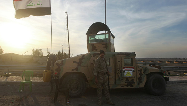 Солдат иракской армии стоит возле автомобиля. Архивное фото