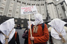 Activists with bags on their heads and ropes around their necks demand an increase in state funding for the treatment of seriously ill people in front of the government building in Kiev, Ukraine, December 23, 2015. The placard reads, "Budget 2016 kills." REUTERS/Valentyn Ogirenko - RTX1ZVAV