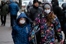 People wearing face masks walk in a street in Kiev, Ukraine, Thursday, Jan. 21 2016. The death toll from the flu outbreak in Ukraine has reached 60, a Health Ministry official said on Thursday. Earlier on Thursday, Kiev prolonged quarantine in schools and kindergartens over the flu and acute respiratory infection outbreak till January 27. (AP Photo/Sergei Chuzavkov)