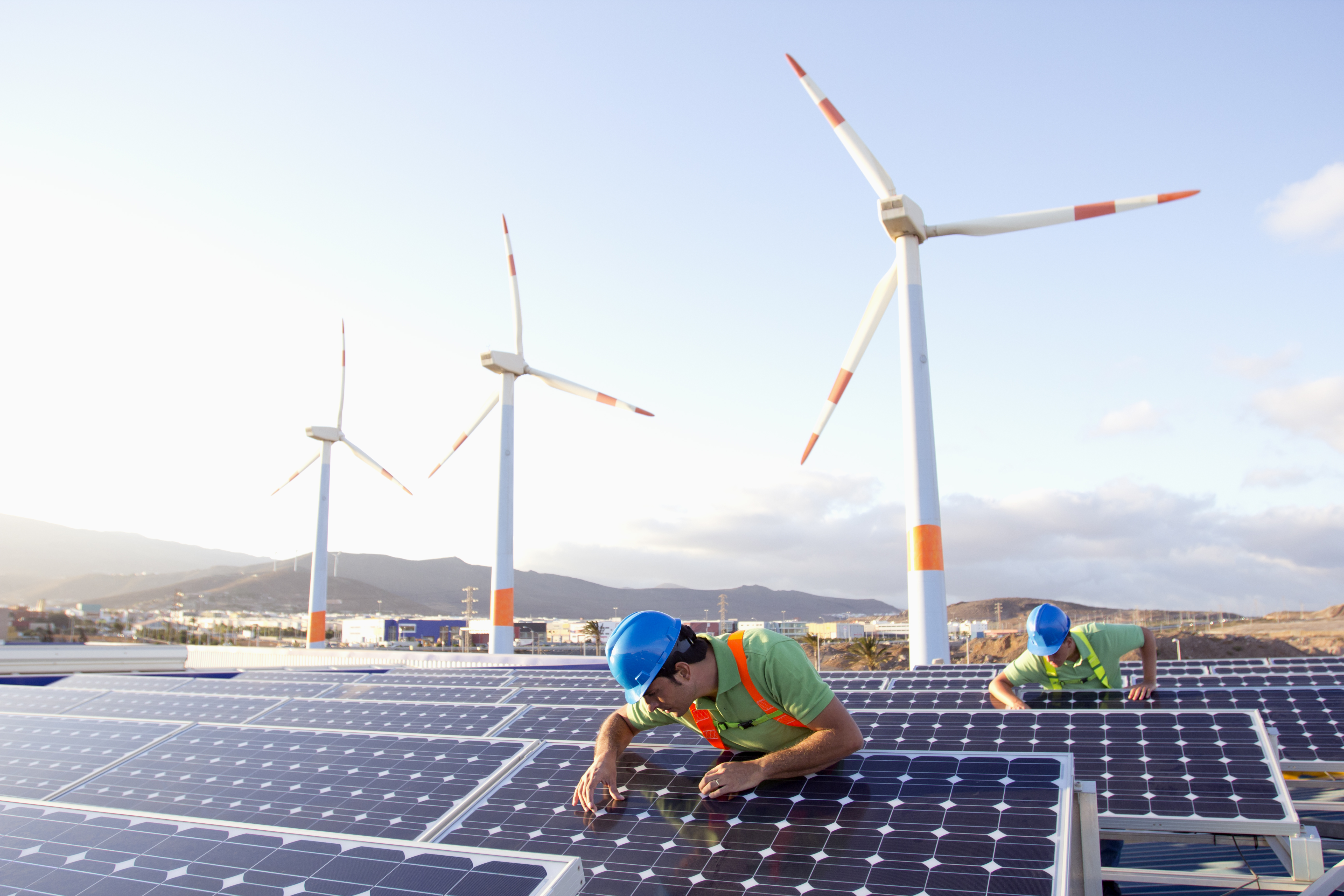 Bild på arbetare som inspekterar solpaneler vid en anläggning för förnybar energi